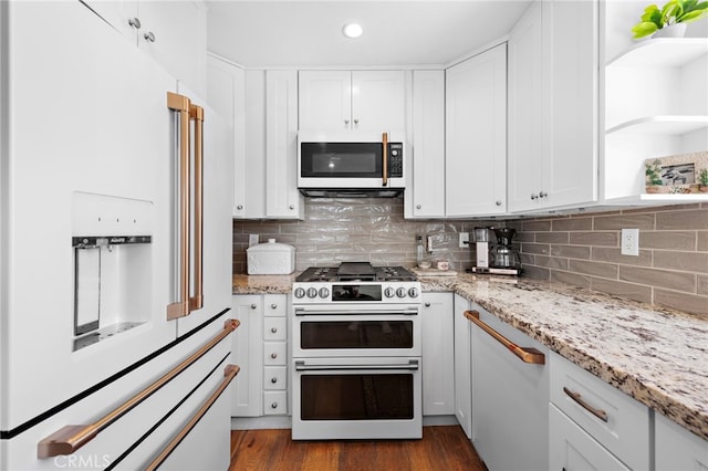 kitchen featuring light stone countertops, white cabinetry, dark hardwood / wood-style floors, and white appliances