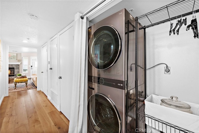 washroom featuring stacked washing maching and dryer and light wood-type flooring