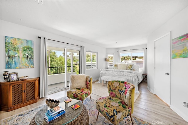 bedroom with access to exterior and light hardwood / wood-style flooring