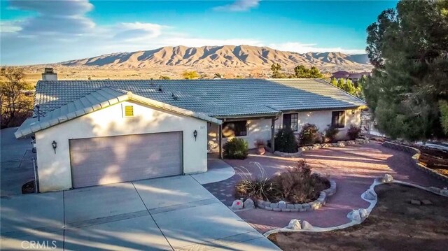 single story home featuring a garage and a mountain view