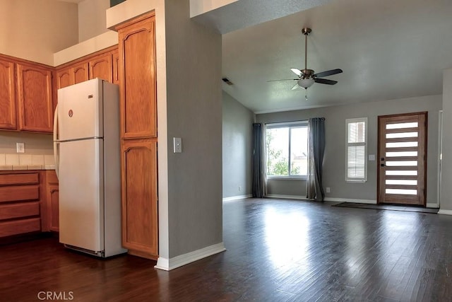 kitchen with ceiling fan, dark hardwood / wood-style floors, white refrigerator, and vaulted ceiling