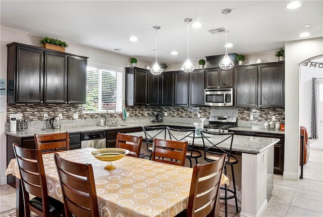 1714 Graybark Ave, Clovis, CA 93619 - kitchen featuring visible vents, a kitchen island, appliances with stainless steel finishes, a sink, and backsplash