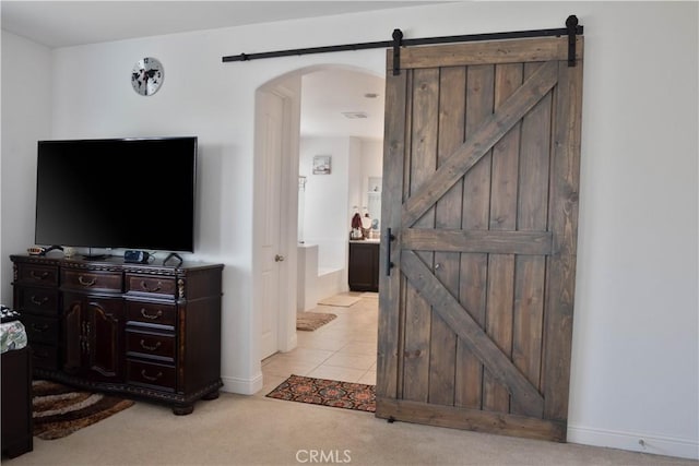 1714 Graybark Ave, Clovis, CA 93619 - interior space with light tile patterned floors, baseboards, arched walkways, a barn door, and light colored carpet