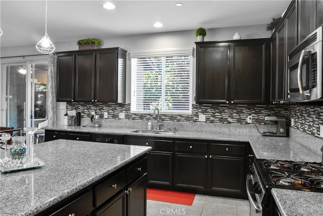 1714 Graybark Ave, Clovis, CA 93619 - kitchen with range with gas cooktop, light tile patterned floors, a sink, stainless steel microwave, and backsplash