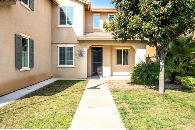 doorway to property with a lawn