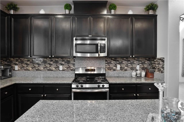 1714 Graybark Ave, Clovis, CA 93619 - kitchen featuring light stone counters, backsplash, and stainless steel appliances