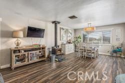 living room with dark hardwood / wood-style flooring and a wood stove