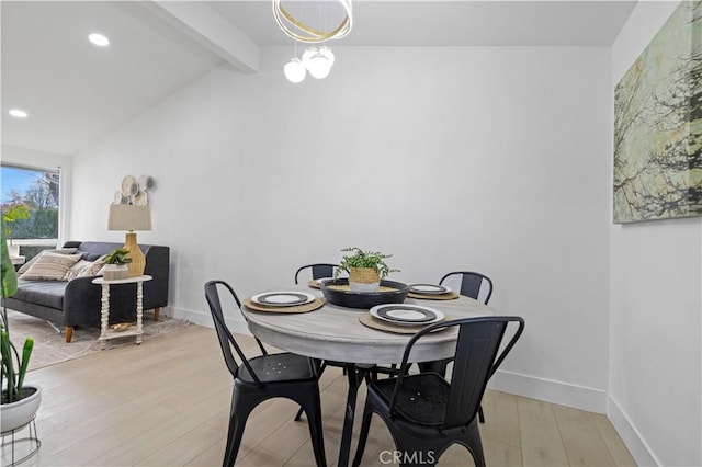 dining area with an inviting chandelier, light hardwood / wood-style flooring, and lofted ceiling with beams