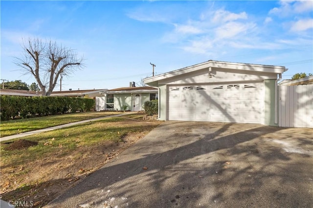 ranch-style house featuring a garage and a front yard