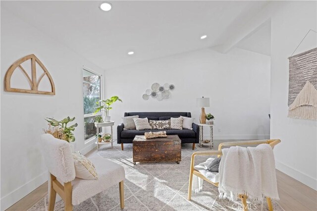 living room with light hardwood / wood-style floors and lofted ceiling with beams