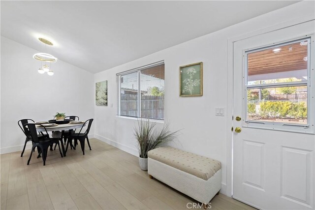 dining space featuring lofted ceiling and light hardwood / wood-style flooring