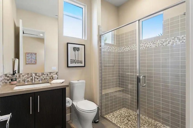 bathroom with toilet, decorative backsplash, plenty of natural light, and an enclosed shower