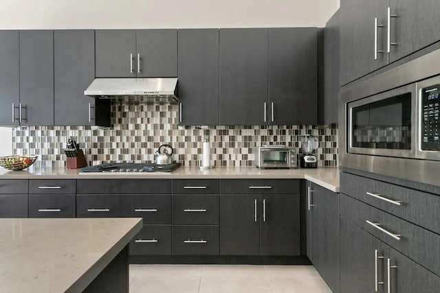 kitchen with decorative backsplash, extractor fan, stainless steel appliances, and light tile patterned flooring