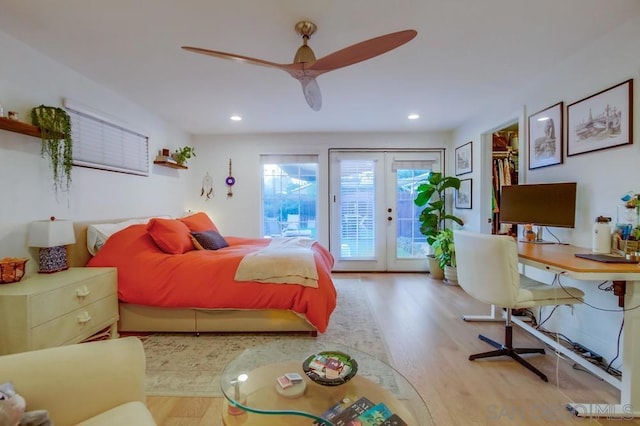 bedroom featuring a spacious closet, french doors, access to outside, ceiling fan, and light hardwood / wood-style flooring