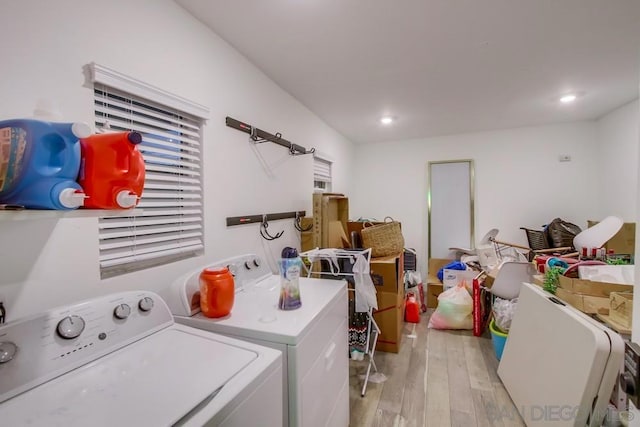 clothes washing area with separate washer and dryer and light hardwood / wood-style flooring