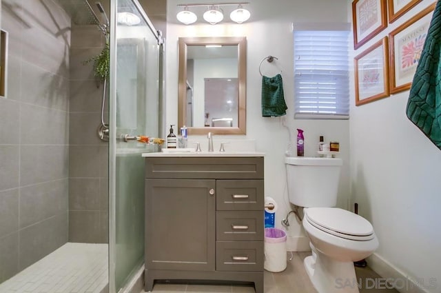 bathroom featuring toilet, a shower with door, and vanity