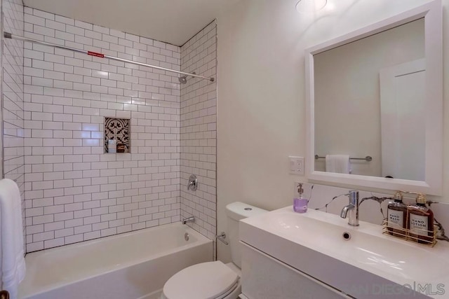 full bathroom featuring toilet, tiled shower / bath, and vanity