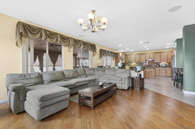 living room featuring an inviting chandelier and light hardwood / wood-style flooring