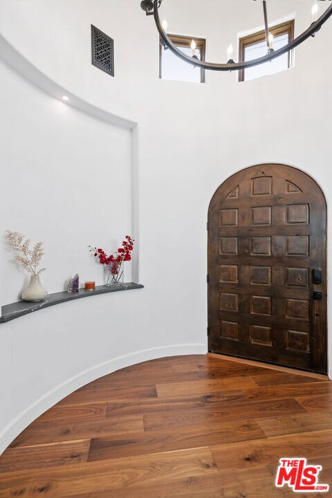 entrance foyer featuring wood-type flooring and a chandelier