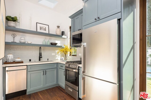 kitchen featuring dark wood-type flooring, sink, backsplash, and appliances with stainless steel finishes