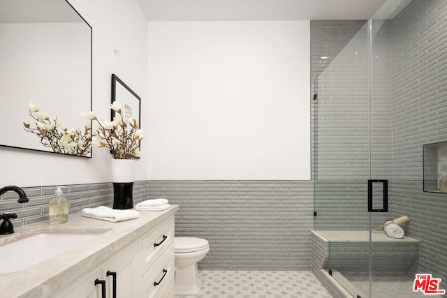 bathroom featuring toilet, tile walls, tile patterned floors, walk in shower, and vanity