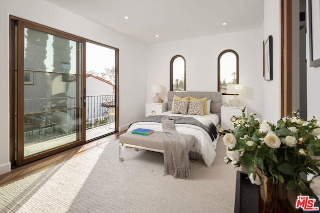 bedroom featuring access to exterior and hardwood / wood-style floors