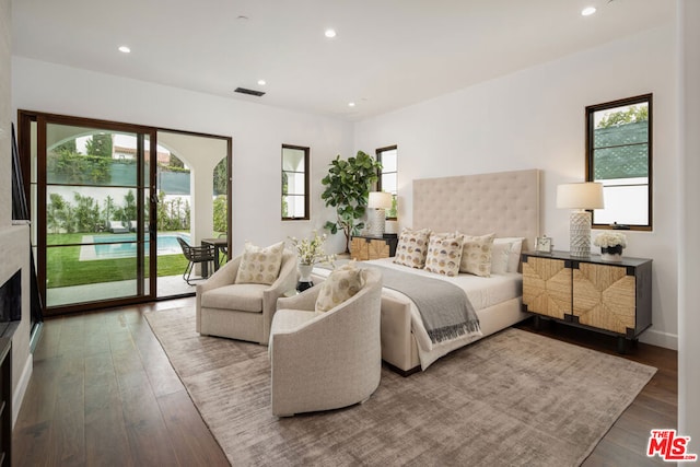 bedroom with hardwood / wood-style floors, access to outside, and multiple windows