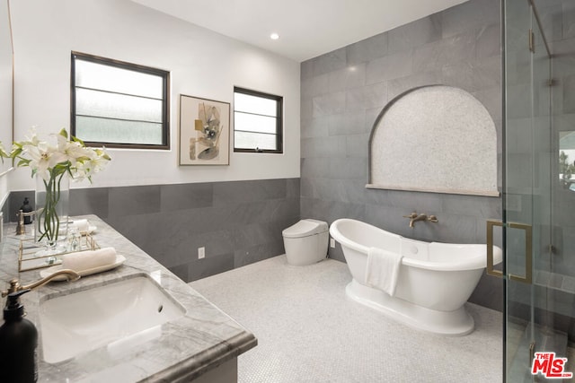 bathroom featuring tile walls, separate shower and tub, and vanity