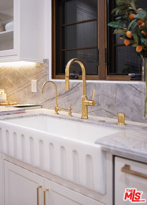 details featuring tasteful backsplash and sink