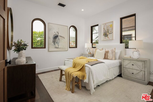 bedroom with multiple windows and light hardwood / wood-style flooring