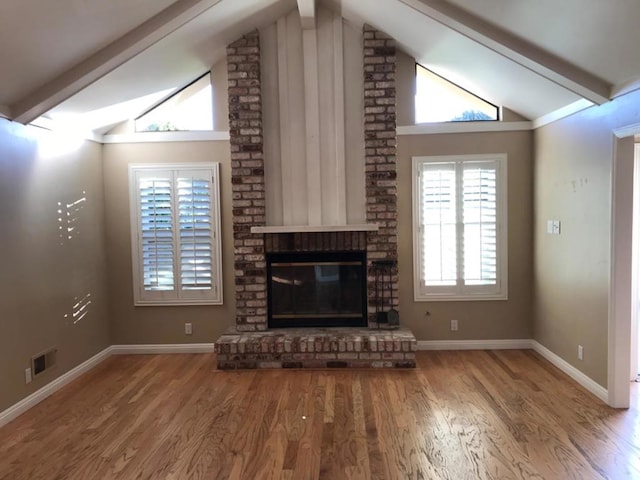 unfurnished living room featuring a fireplace, vaulted ceiling, and hardwood / wood-style flooring