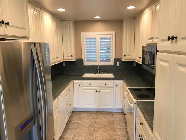 kitchen with sink, appliances with stainless steel finishes, and white cabinetry