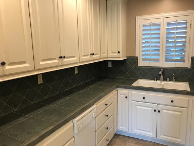 kitchen featuring sink, decorative backsplash, and white cabinetry