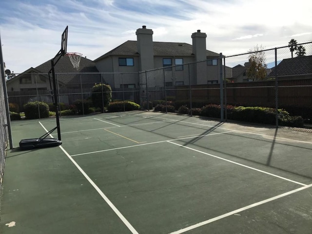 view of tennis court featuring basketball hoop