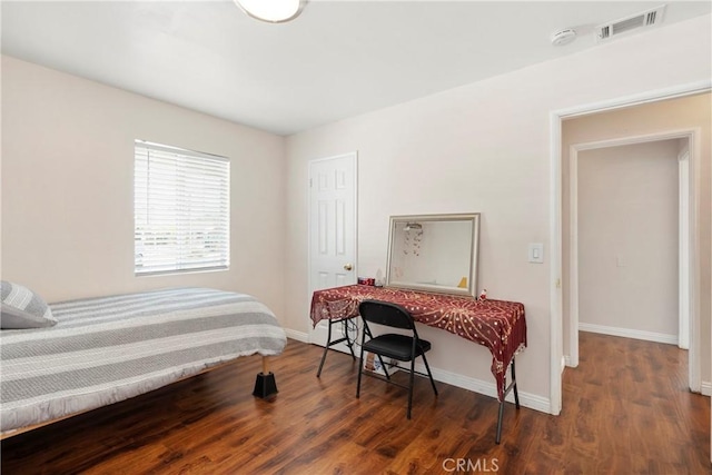 bedroom with dark hardwood / wood-style flooring