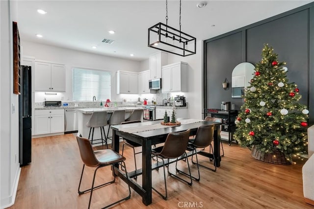 dining area with sink and light hardwood / wood-style flooring