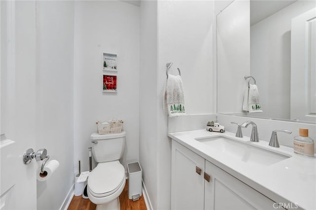 bathroom with toilet, vanity, and hardwood / wood-style flooring