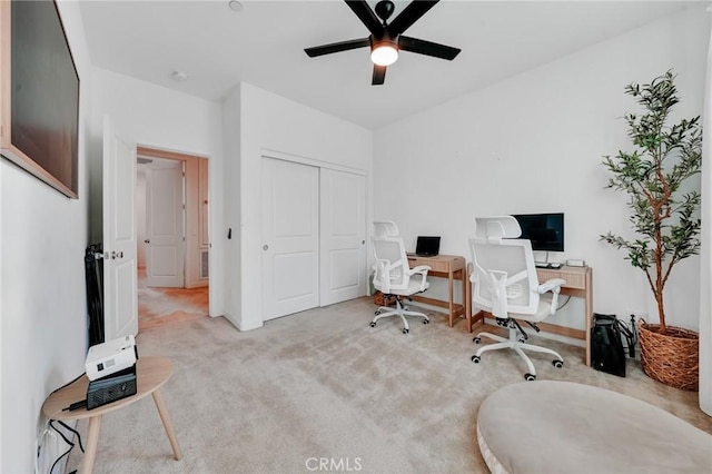 office space featuring light carpet and ceiling fan