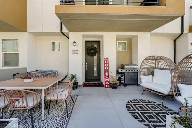 property entrance with central AC unit, a balcony, and a patio