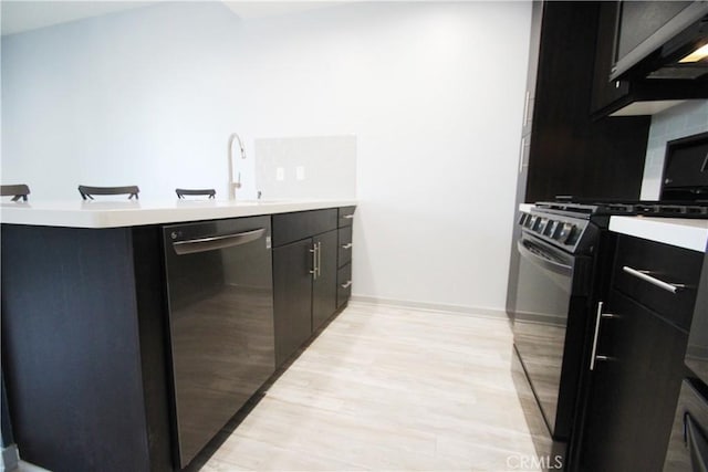 kitchen with black range oven, light wood-type flooring, dishwasher, and sink