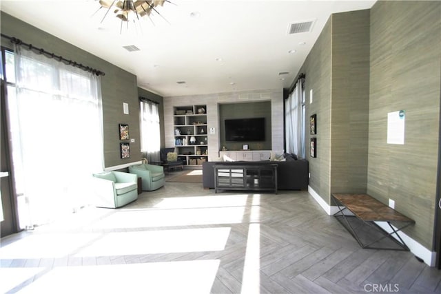 living room with light parquet floors and built in shelves