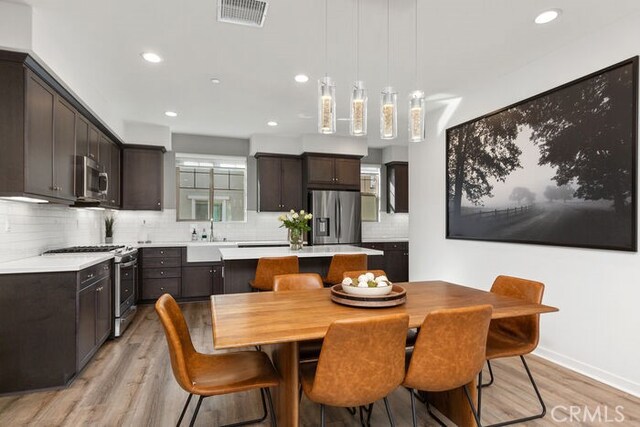 dining space with sink and light hardwood / wood-style flooring