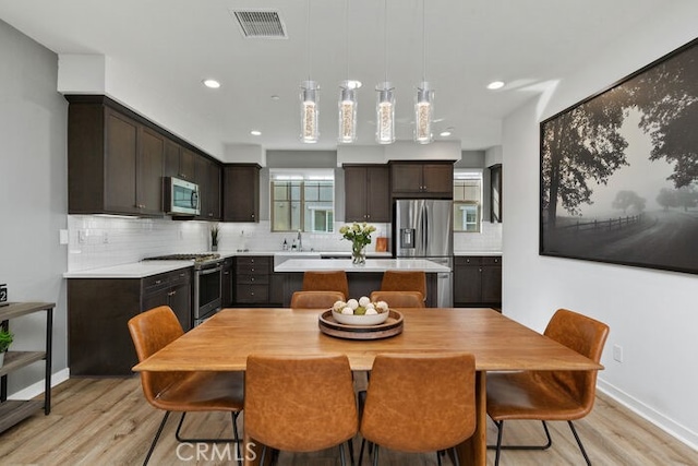 dining space with light hardwood / wood-style floors and sink