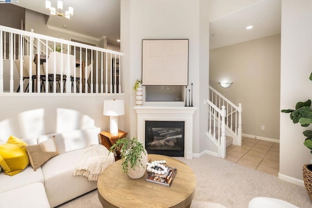 living room with tile patterned floors, crown molding, and an inviting chandelier