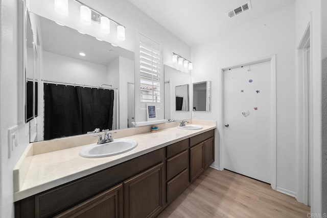 bathroom with wood-type flooring, vanity, and a shower with curtain