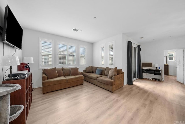 living room featuring a wealth of natural light and light hardwood / wood-style flooring