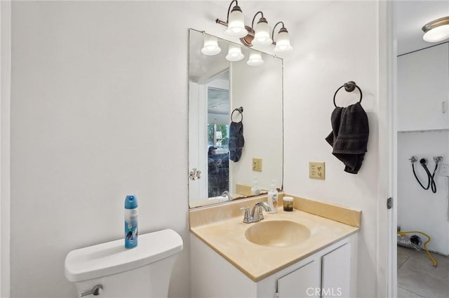 bathroom with toilet, vanity, and tile patterned floors