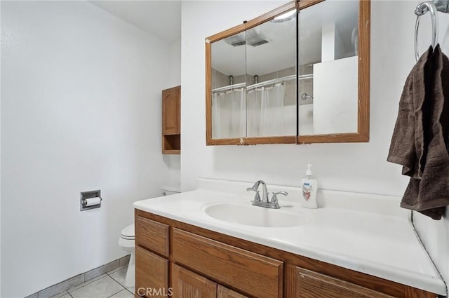 bathroom featuring vanity, tile patterned flooring, toilet, and walk in shower