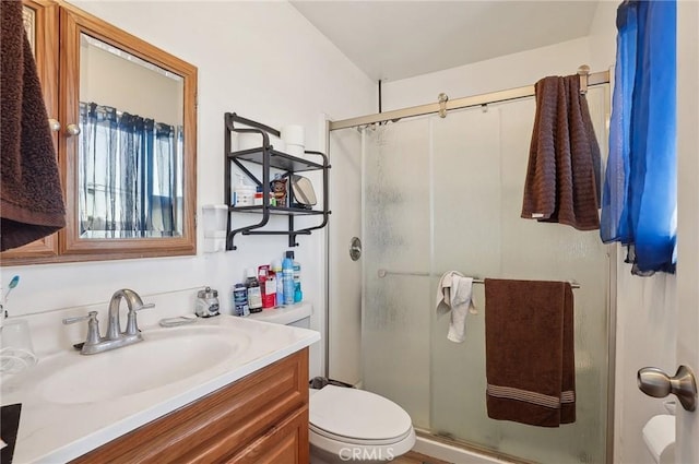 bathroom featuring toilet, walk in shower, and vanity