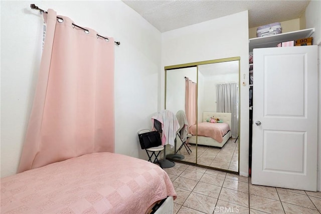 tiled bedroom with a closet and a textured ceiling